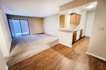 an empty living room and kitchen with a sliding glass door at Deercross Apartments, Cincinnati, Ohio